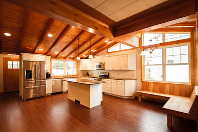 Example of a mid-sized arts and crafts l-shaped ceramic tile and brown floor eat-in kitchen design in Other with an undermount sink, white cabinets, quartzite countertops, white backsplash, subway tile backsplash, stainless steel appliances, an island and shaker cabinets