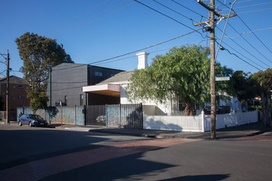 Ejemplo de fachada negra actual de tamaño medio de dos plantas con revestimiento de madera y tejado a dos aguas