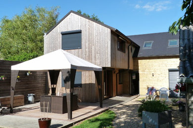 Cette photo montre une façade de maison tendance en bois à un étage et de taille moyenne avec un toit à deux pans.