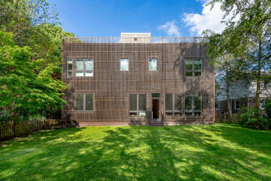 Foto de fachada de casa marrón minimalista de dos plantas con revestimiento de madera y tejado plano