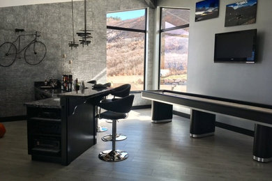 Example of a huge trendy enclosed laminate floor family room design in Las Vegas with a bar, gray walls and a wall-mounted tv