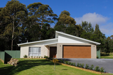 Beach style one-storey exterior in Sydney with wood siding and a flat roof.