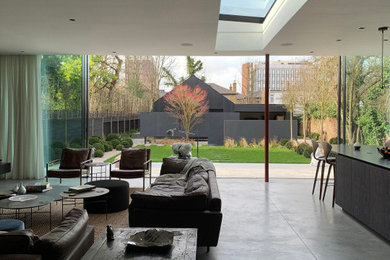 Foto de cine en casa abierto moderno de tamaño medio con paredes grises, suelo de cemento, pared multimedia y suelo gris