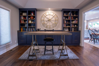 Transitional freestanding desk medium tone wood floor, brown floor and vaulted ceiling study room photo in Kansas City with gray walls