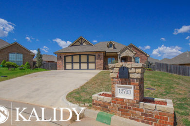Inspiration for a large transitional multicolored one-story brick exterior home remodel in Oklahoma City with a shingle roof