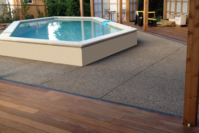 Photo of a small traditional backyard custom-shaped pool in Other with decking and a water feature.