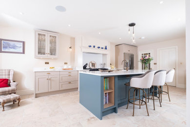 Inspiration for a large traditional single-wall open plan kitchen in Cardiff with a belfast sink, shaker cabinets, quartz worktops, limestone flooring, an island, white worktops and a chimney breast.