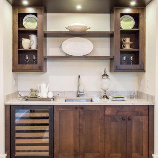 シアトルの地中海スタイルのおしゃれなウェットバー (アンダーカウンターシンク、シェーカースタイル扉のキャビネット、濃色木目調キャビネット、白いキッチンカウンター) の写真