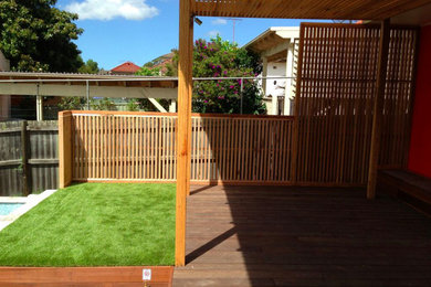 This is an example of a mid-sized backyard verandah in Sydney with decking and a pergola.