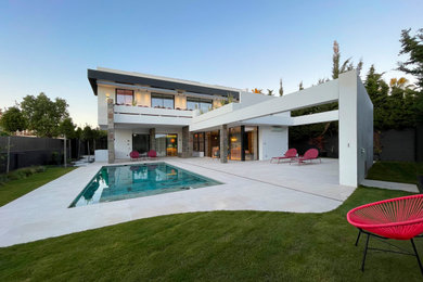 Ejemplo de casa de la piscina y piscina alargada exótica grande rectangular en patio delantero con suelo de baldosas