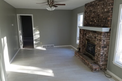 Elegant living room photo in Kansas City with gray walls, a standard fireplace and a brick fireplace