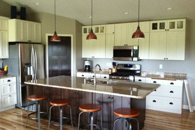 Eat-in kitchen - mid-sized modern single-wall light wood floor eat-in kitchen idea in Other with an undermount sink, flat-panel cabinets, white cabinets, granite countertops, stainless steel appliances and an island