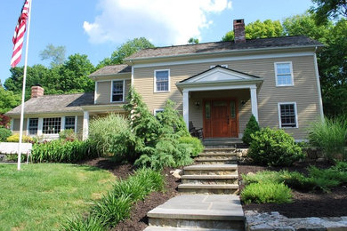 Inspiration for a large timeless beige two-story exterior home remodel in New York