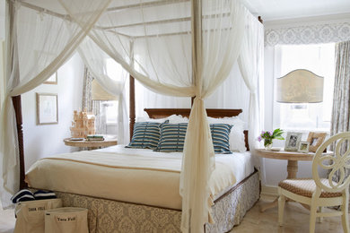 This is an example of a beach style bedroom in Other with white walls and beige floor.