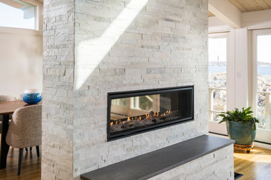 Inspiration for a mid-sized living room remodel in Boston with a two-sided fireplace and a stacked stone fireplace
