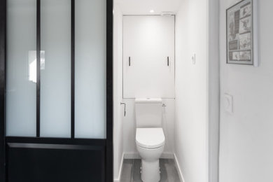 Exemple d'un petit WC et toilettes tendance avec WC à poser, un carrelage blanc, des carreaux de céramique, un mur blanc, sol en béton ciré et un lavabo de ferme.