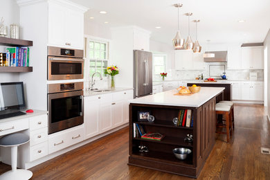 Example of a large transitional l-shaped dark wood floor kitchen design in DC Metro with white backsplash, stainless steel appliances, two islands, an undermount sink, shaker cabinets and white cabinets