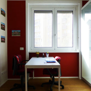 Inspiration for a medium sized modern home studio in Milan with red walls, light hardwood flooring, a freestanding desk and beige floors.