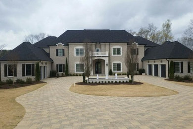 Example of a large classic gray two-story stone exterior home design in Atlanta with a hip roof