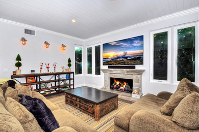 Game room - large traditional open concept dark wood floor game room idea in Orange County with white walls, a standard fireplace, a stone fireplace and a media wall