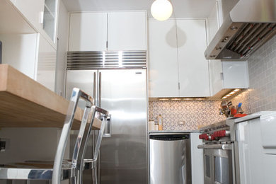 Mid-sized trendy l-shaped ceramic tile enclosed kitchen photo in Chicago with a farmhouse sink, flat-panel cabinets, white cabinets, marble countertops, stainless steel appliances, no island, multicolored backsplash and porcelain backsplash