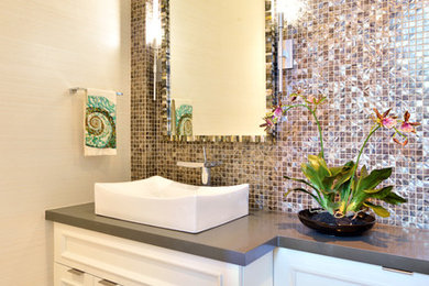 Inspiration for a mid-sized modern powder room in Miami with recessed-panel cabinets, white cabinets, beige tile, mosaic tile, beige walls, a vessel sink, engineered quartz benchtops, beige floor and grey benchtops.