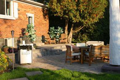 Mid-sized elegant backyard stone patio kitchen photo in Toronto with no cover