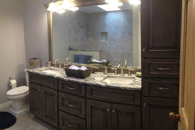 Doorless shower - mid-sized transitional 3/4 beige tile and porcelain tile porcelain tile doorless shower idea in Orlando with an undermount sink, raised-panel cabinets, distressed cabinets, marble countertops, a two-piece toilet and blue walls