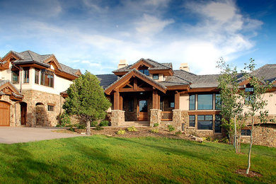 Inspiration for a huge rustic beige two-story mixed siding exterior home remodel in Denver