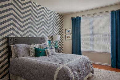 Example of a mid-sized transitional guest medium tone wood floor bedroom design in New York with gray walls