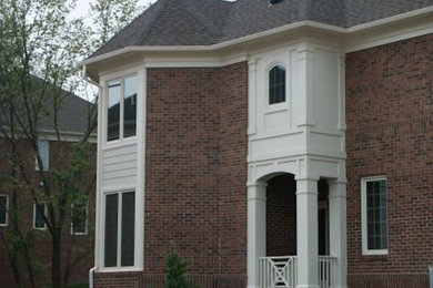 Large red two-story brick exterior home idea in DC Metro