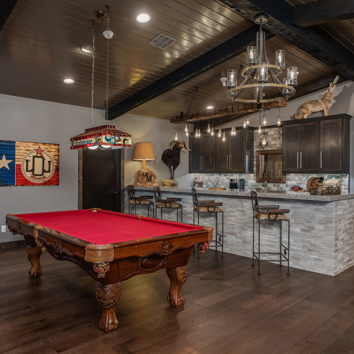 Inspiration for a large rustic galley dark wood floor and brown floor wet bar remodel in Austin with shaker cabinets, dark wood cabinets, limestone countertops, multicolored backsplash, glass tile bac