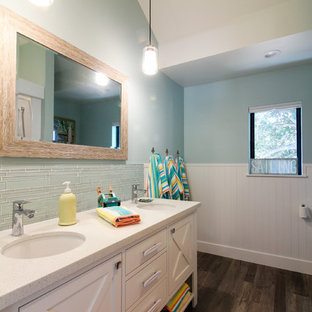 Immagine di una stanza da bagno per bambini minimalista di medie dimensioni con ante bianche, piastrelle di vetro, pareti blu, pavimento in laminato, lavabo sottopiano, top in quarzite, pavimento marrone e top beige