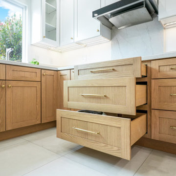 Modern White and Natural Oak Kitchen with Brass Hardware and Quartz Backsplash