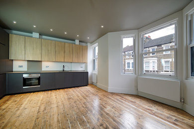 Design ideas for a medium sized contemporary open plan living room in London with grey walls, medium hardwood flooring and brown floors.