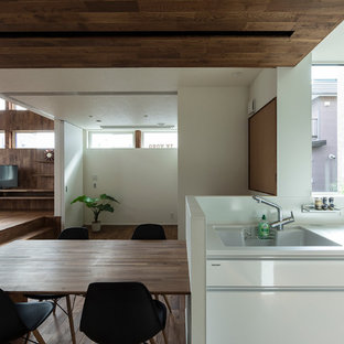 札幌のモダンスタイルのおしゃれなキッチン (一体型シンク、フラットパネル扉のキャビネット、白いキャビネット、シルバーの調理設備の、濃色無垢フローリング) の写真