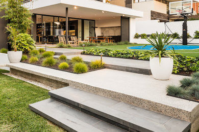 Design ideas for a large contemporary backyard garden in Melbourne with natural stone pavers.