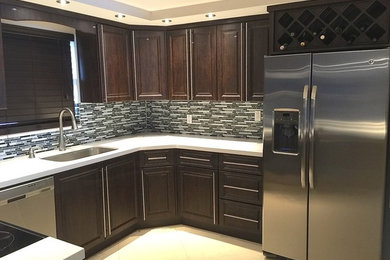 Photo of a medium sized world-inspired u-shaped enclosed kitchen in Miami with a submerged sink, raised-panel cabinets, dark wood cabinets, engineered stone countertops, multi-coloured splashback, matchstick tiled splashback, stainless steel appliances, marble flooring, a breakfast bar and beige floors.