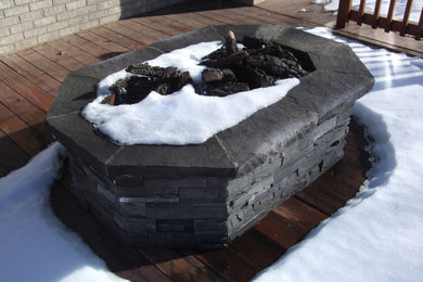 Example of a mountain style backyard deck design in Denver with a fire pit