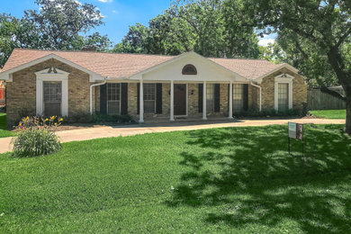 This is an example of a large traditional front porch design in Houston.
