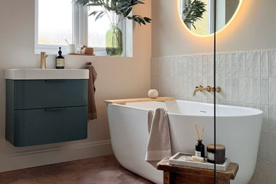 This is an example of a contemporary half tiled bathroom in Other with flat-panel cabinets, green cabinets, a freestanding bath, a walk-in shower, a two-piece toilet, white tiles, porcelain tiles, beige walls, ceramic flooring, brown floors, an open shower, a single sink and a floating vanity unit.