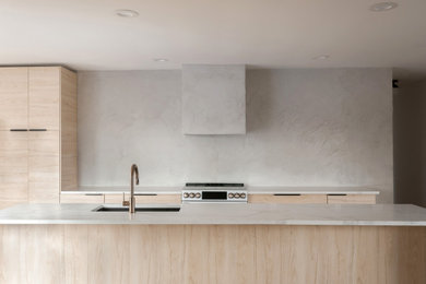 Inspiration for a large 1950s light wood floor eat-in kitchen remodel in Nashville with an undermount sink, flat-panel cabinets, light wood cabinets, quartz countertops, gray backsplash, white appliances, an island and white countertops