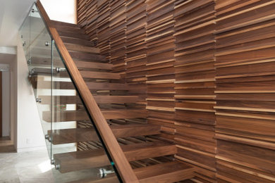 Example of a large trendy wooden straight open, glass railing and wood wall staircase design in Vancouver