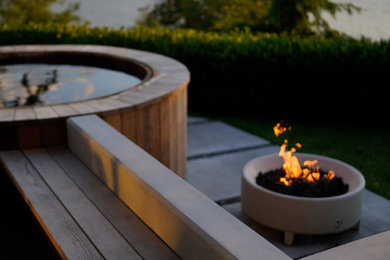 Inspiration for a mid-sized contemporary backyard concrete patio remodel in Seattle with a fire pit and a pergola
