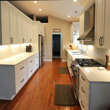 White Kitchen with Quartz Countertop, Galley Workstation and Large Subway Tile