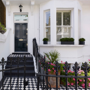 ロンドンの片開きドアヴィクトリアン調のおしゃれな玄関ドア (白い壁、黒いドア) の写真