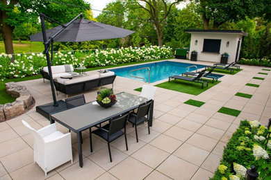 This is an example of a mid-sized contemporary backyard garden in Toronto with natural stone pavers.