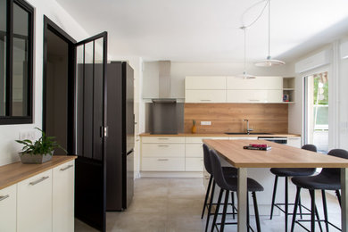 Cette photo montre une cuisine linéaire tendance de taille moyenne avec un placard à porte vitrée, des portes de placard blanches, un plan de travail en bois et îlot.