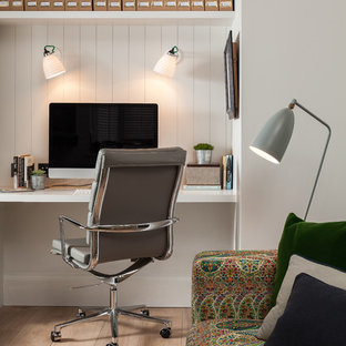 Idéer för att renovera ett lantligt hemmabibliotek, med vita väggar, ljust trägolv och ett inbyggt skrivbord