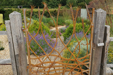 Photo of an eclectic front garden in Sussex with a metal fence.